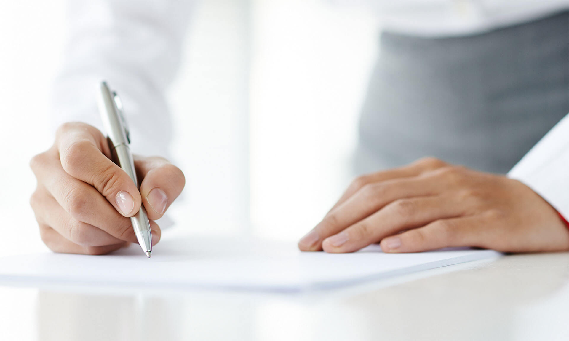 Woman writing on a piece of paper.