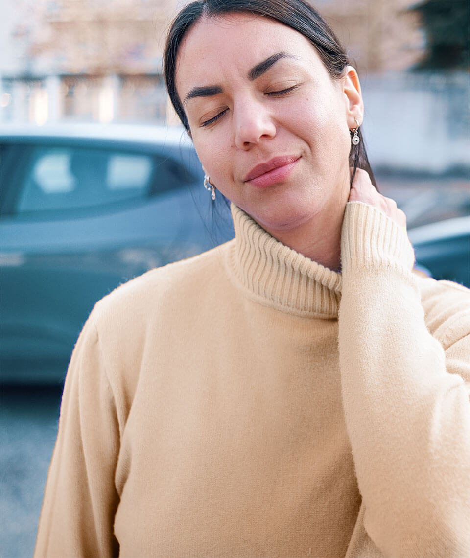 Woman holding neck as if she's in pain.