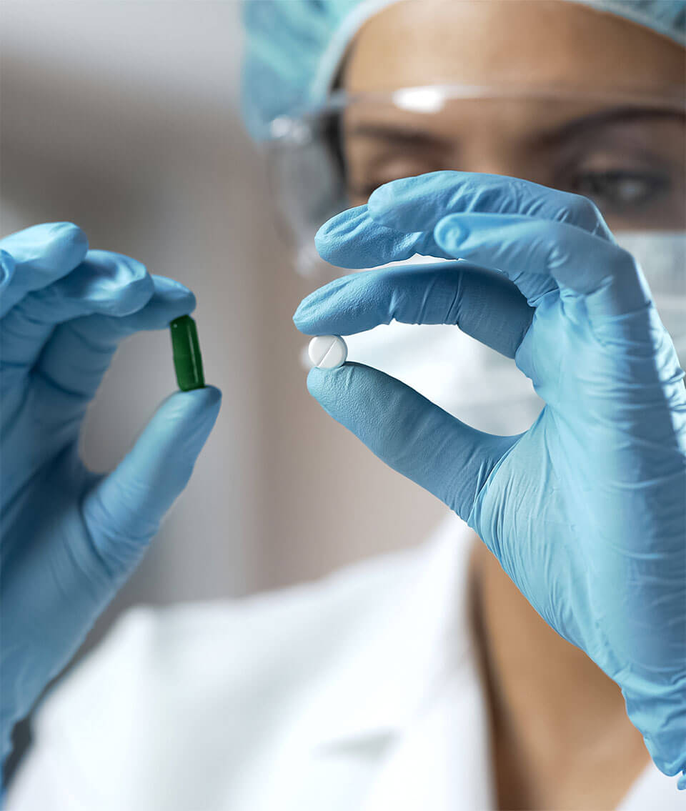 A medical staff member holding two drugs next to each other.